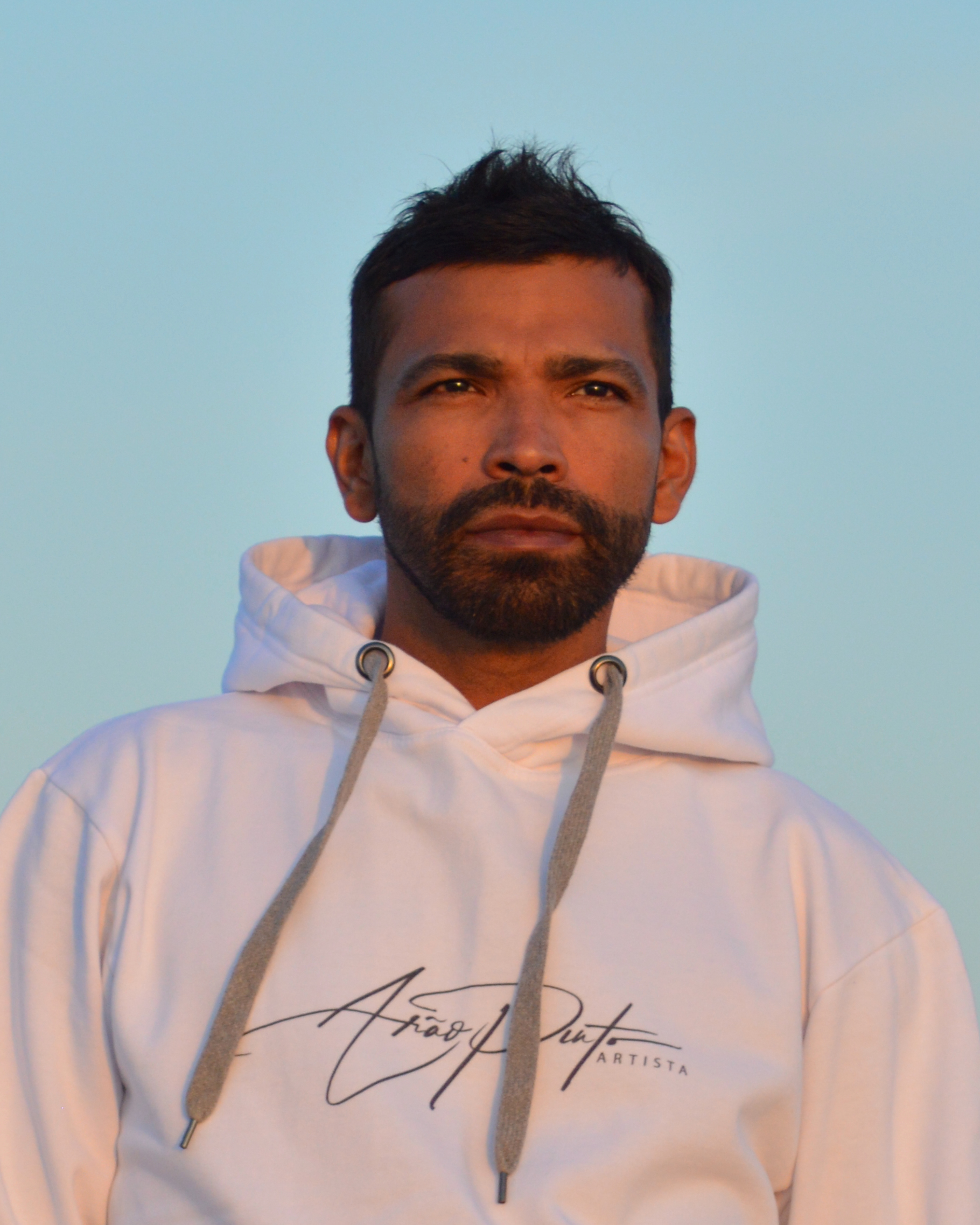 Portrait_Arão Pinto_v1 Portrait von Arão Pinto angestrahlt von der Abendsonne und im Hintergrund ein blauer Himmel.